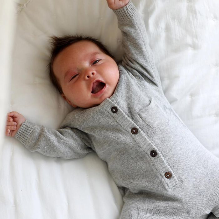Milan Organic Baby Romper / Knit Sweater Button Jumpsuit close up on yawning baby