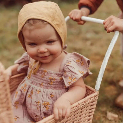 Haven Toddler Organic Floral Dress - Lavender on baby model with bonnet in a buggy