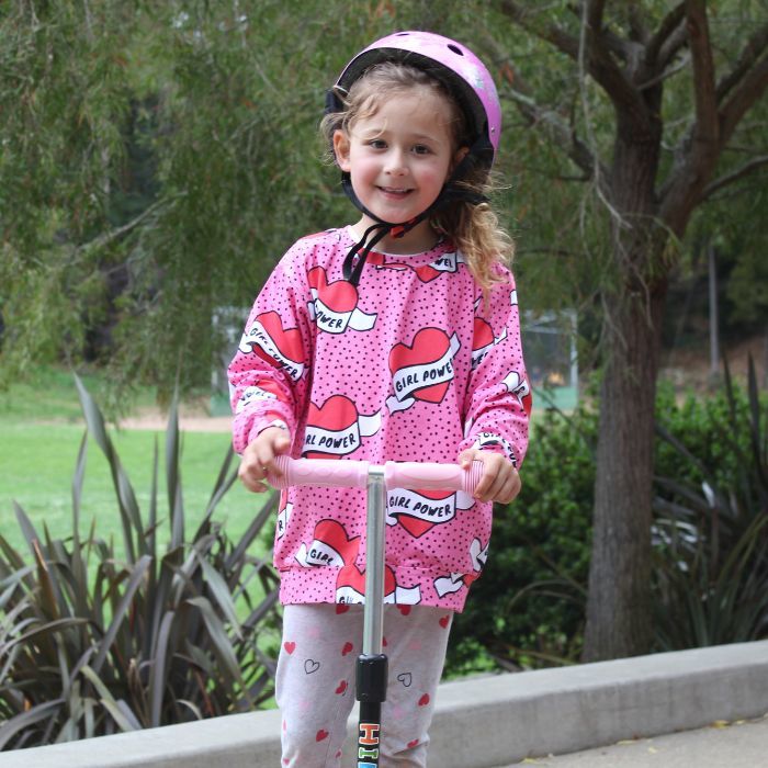 Organic toddler pullover top - girl power pink hearts - on model riding scooter